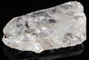 A raw quartz crystal with a clear, glassy appearance and dark inclusions on a black surface.