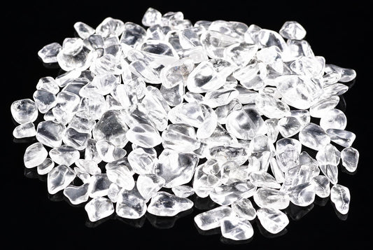 A pile of small, clear quartz chips on a dark surface.