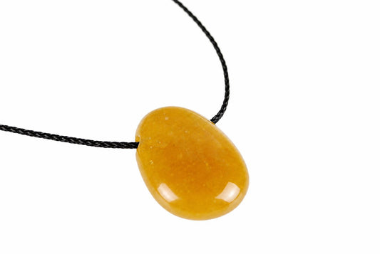 A smooth, oval-shaped pendant in warm yellow-orange tones hangs from a black cord against a white background.
