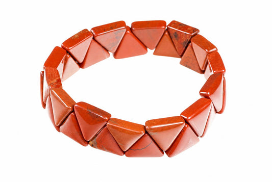 A bracelet made of polished red triangular stones arranged in a circle on a white background.