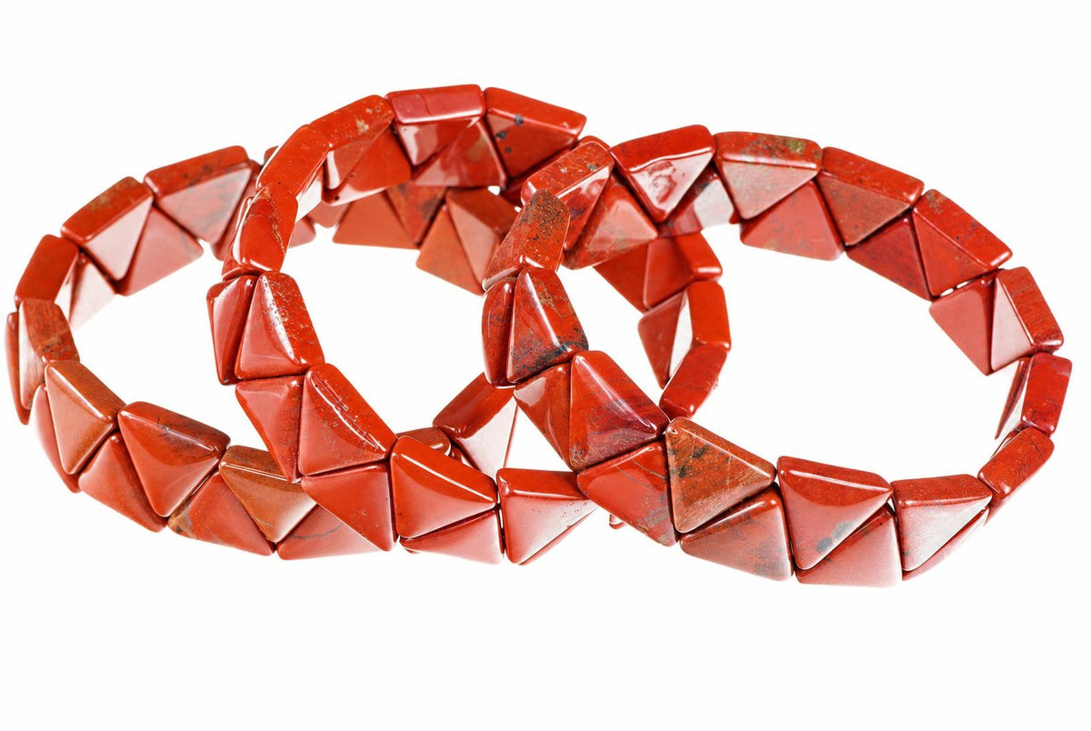 Two red jasper bracelets with triangular beads arranged in a loop on a white background.