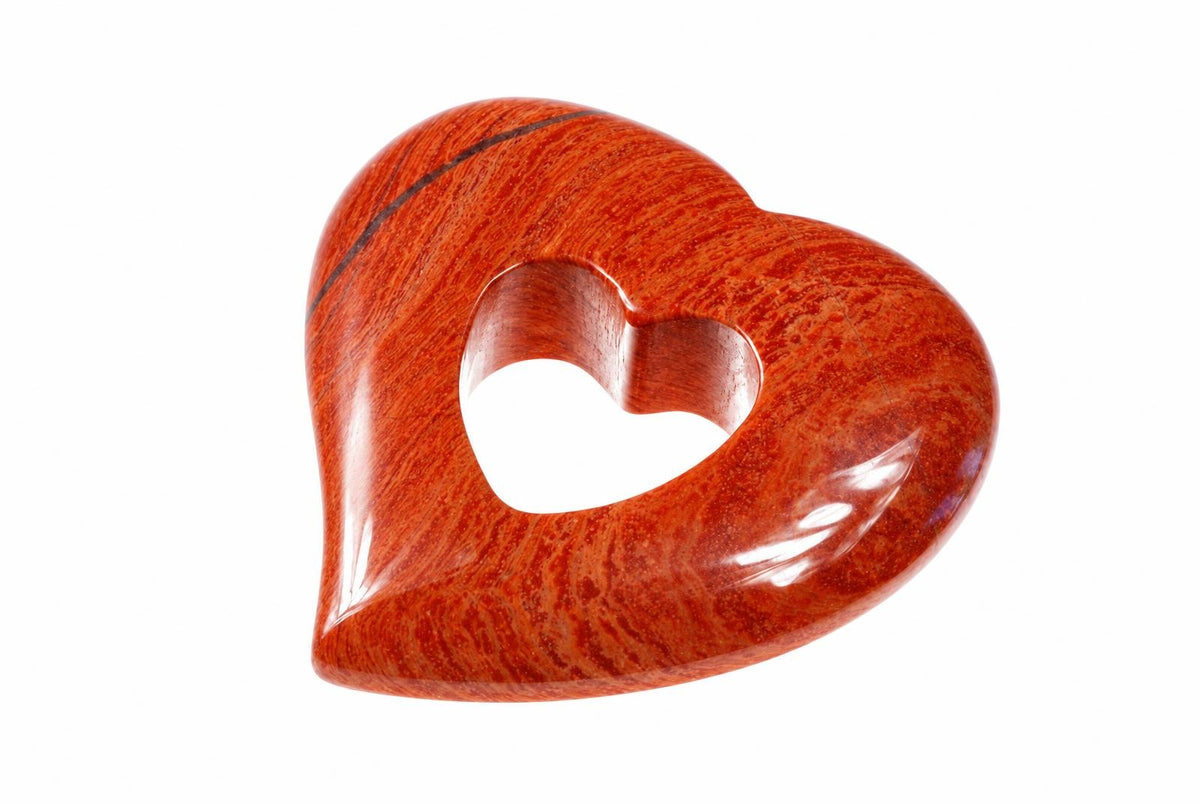 A polished, reddish-brown heart-shaped pendant with a central heart cutout and dark veining on a white background.