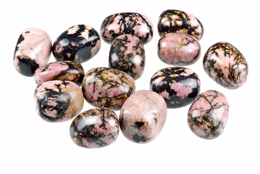A group of polished rhodonite stones with pink, black and brown patterns on a white background.