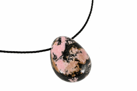 A polished pendant with pink, black and brown patterns on a dark surface, attached to a black cord against a white background.