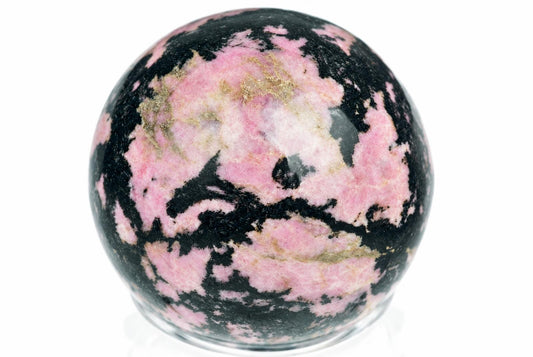A polished Rhodonite sphere with pink, black and gold-coloured patterns on a white surface.