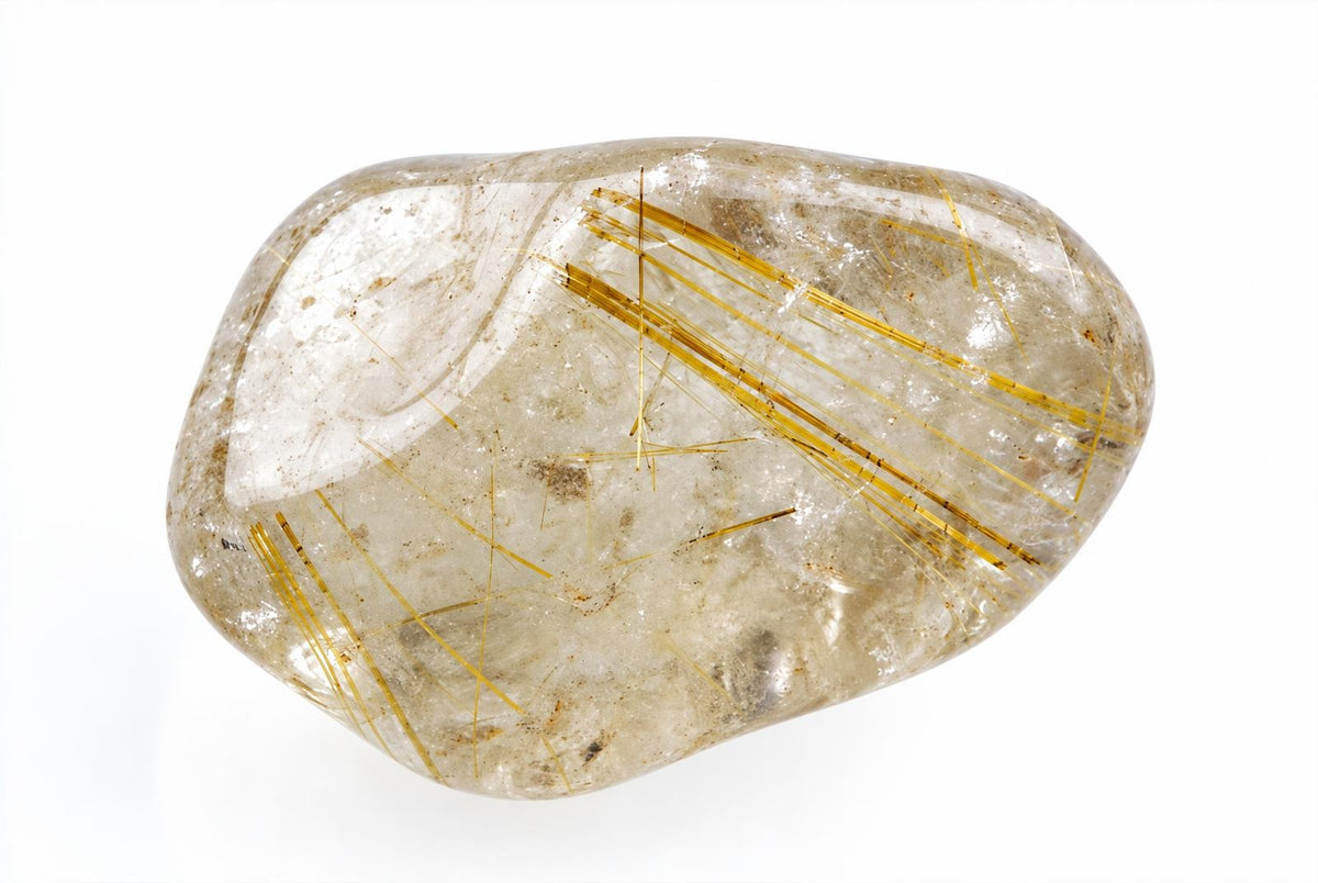 A polished, translucent quartz stone with golden rutile needles inside, set against a white background.