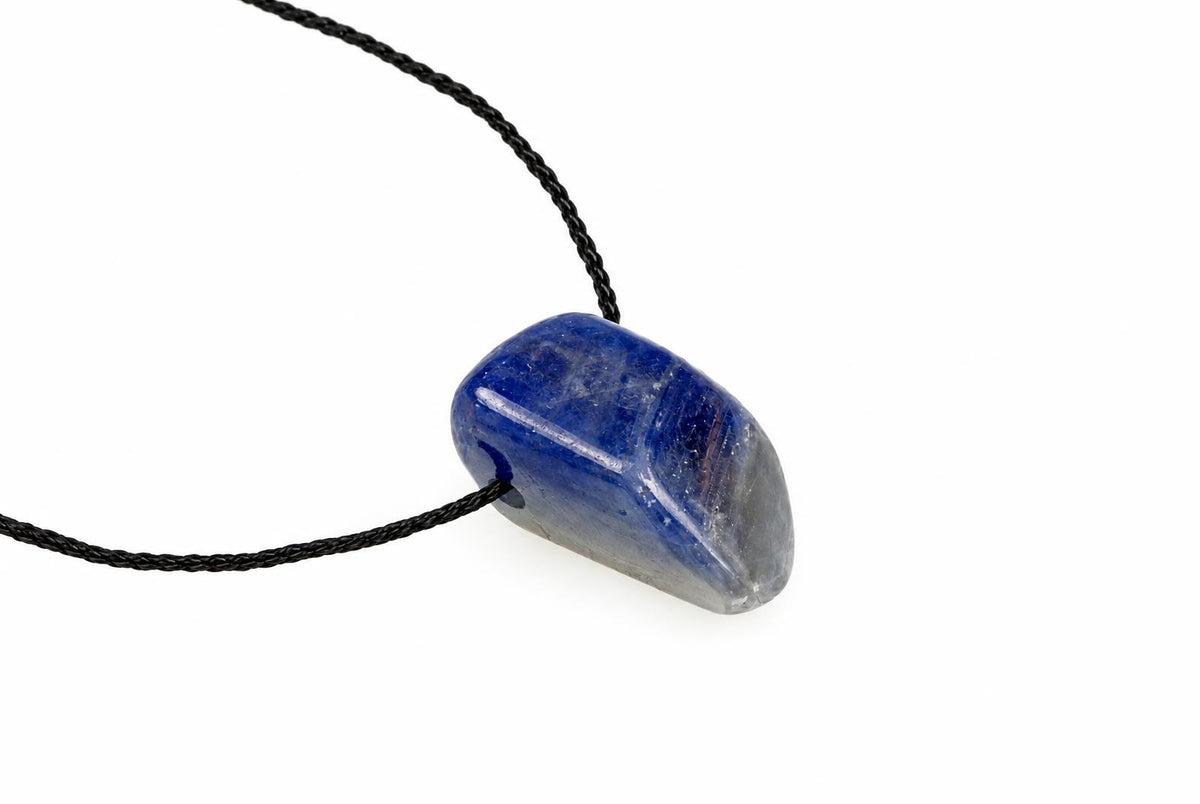 A blue and grey polished stone pendant on a black cord, set against a white background.