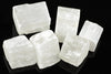 Five white selenite cubes with visible striations arranged on a dark reflective surface.