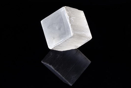 A translucent, white cube with a reflective surface sits on a dark background.