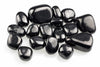 Smooth black stones with rounded irregular shapes and bright surface reflections are grouped on white.