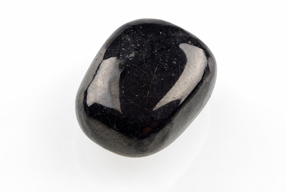 A polished, smooth black stone with a glossy surface and silver-toned reflections on a white background.