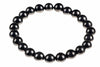 A bracelet made of round, dark black beads arranged in a circle on a white background.