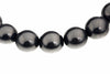 A row of round, dark grey beads with a metallic sheen on a white background.