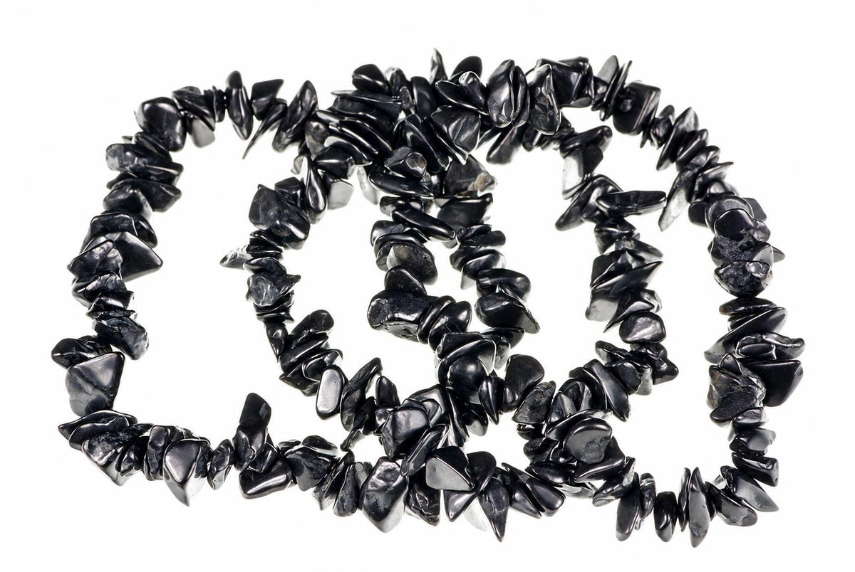 A necklace of irregular black chips arranged in a loose spiral on a white background.