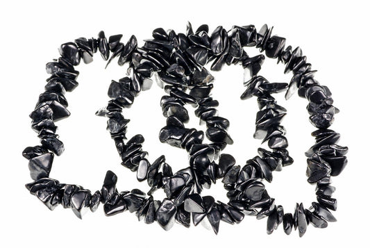 A necklace of irregular black chips arranged in a loose spiral on a white background.