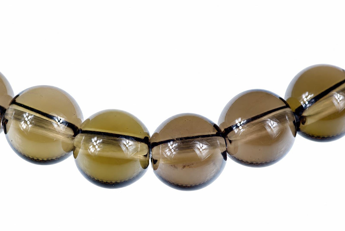 A row of round, translucent brown beads with dark horizontal bands on a white background.