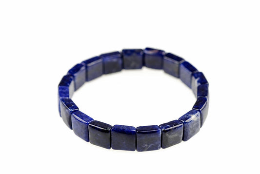 A bracelet made of square sodalite beads in deep blue, arranged in a circle on a white surface.
