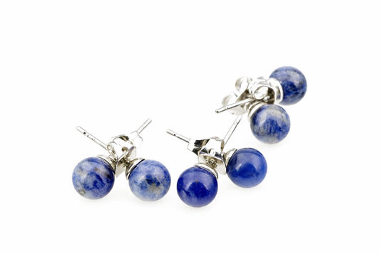 Two pairs of stud earrings with round sodalite beads and silver-toned posts on a white surface.