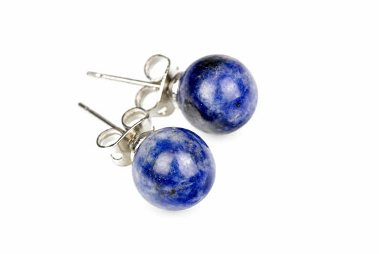 A pair of round blue sodalite stud earrings with cloudy white patches and silver-tone posts is shown against a white background.