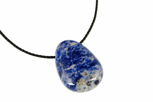 A polished sodalite pendant with deep blue and white patterns hangs from a black cord against a white background.