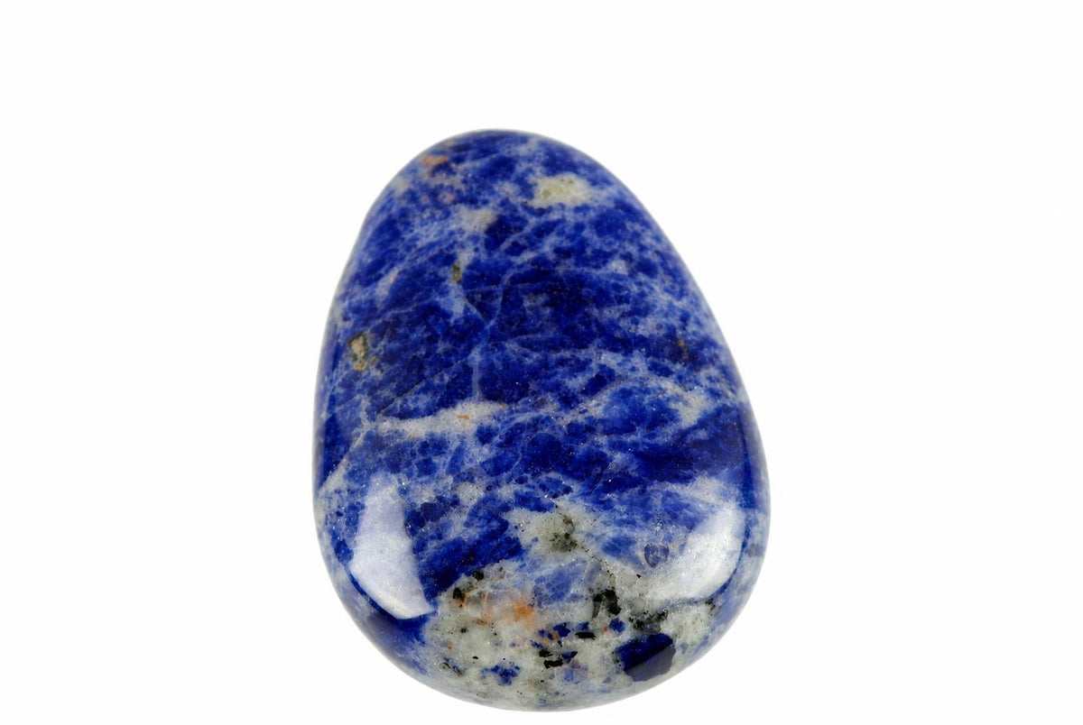 A polished sodalite pendant with deep blue and white patterns, shaped like a drop on a pale surface.