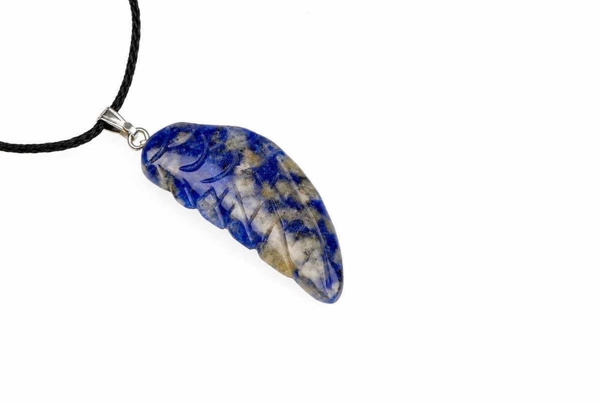 A blue and white sodalite wing pendant shows carved feather grooves and dark patches, hanging from a black cord on white.
