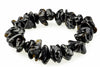 A bracelet made of irregular, glossy black beads with brown and silver-toned inclusions on a white surface.