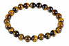 A circular bracelet of glossy round golden-brown beads with dark bands rests on a white background.