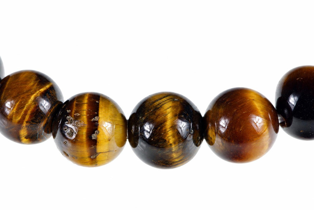 A row of round tiger eye beads with golden brown and black stripes on a white background.