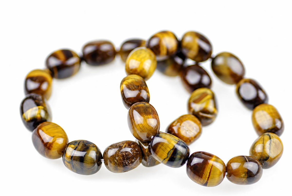 Two overlapping bracelets of glossy rounded golden-brown beads with dark bands rest on white.