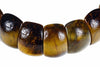 A bracelet with large, polished beads showing tiger eye patterns in dark brown and golden yellow tones against a white background.
