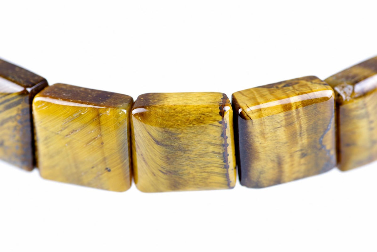 A bracelet with square beads of polished tiger eye stone, showing yellow and brown stripes on a white background.