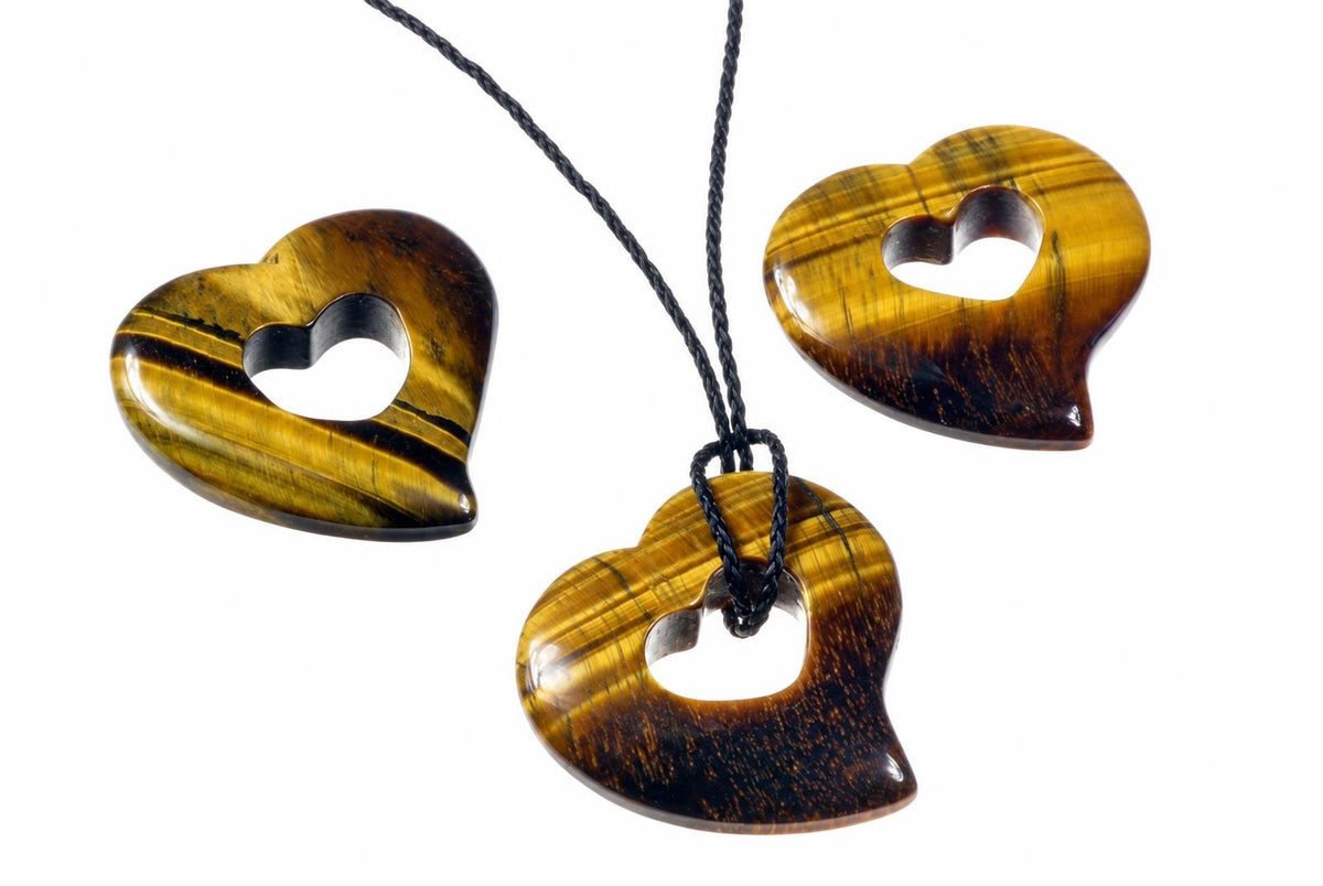 A black cord passes through a polished tiger eye heart pendant beside matching pendants on a white background.