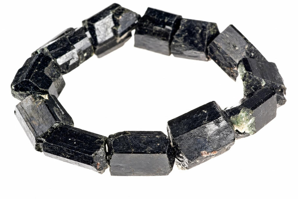 A bracelet made of raw, dark black schorl tourmaline crystals arranged in a circle on a white background.
