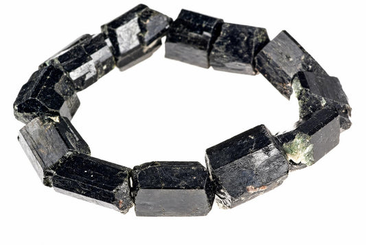 A bracelet made of raw, dark black schorl tourmaline crystals arranged in a circle on a white background.