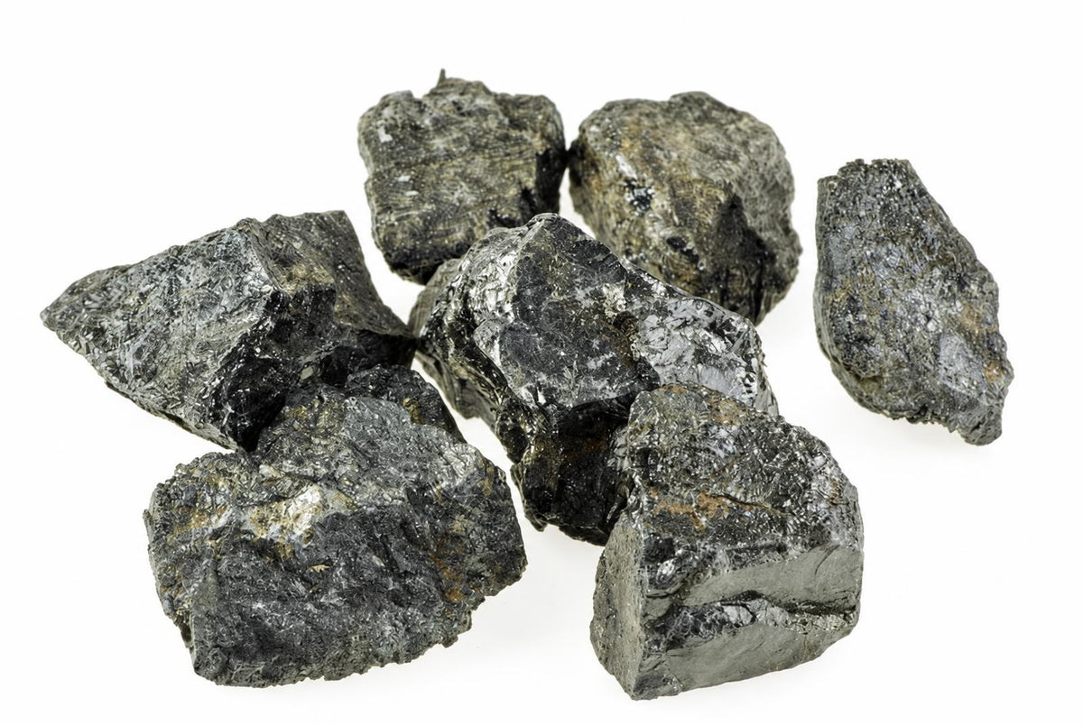 A pile of seven rough, dark grey to black mineral chunks with a metallic sheen on a white background.