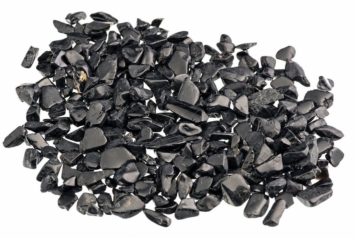 A pile of small, dark black stones with a glossy finish on a white background.