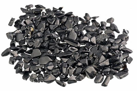 A pile of small, dark black stones with a glossy finish on a white background.