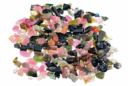 A pile of small, rough tourmaline gemstones in pink, black, green, and orange on a white background.