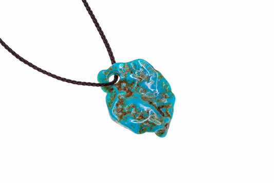 A turquoise pendant with brown matrix patterns hangs from a dark cord against a white background.