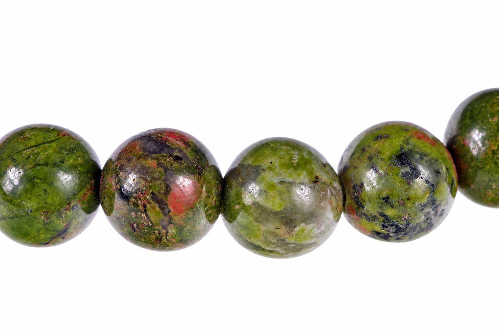 A row of round beads with green, red and black speckled patterns on a white background.