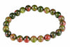A bracelet of round beads with green, red and black speckled patterns on a white background.