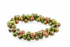 A bracelet of round beads with green and reddish-brown speckled patterns on a white background.
