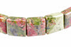 A bracelet of polished square beads with pink, green and grey speckled patterns on a white background.