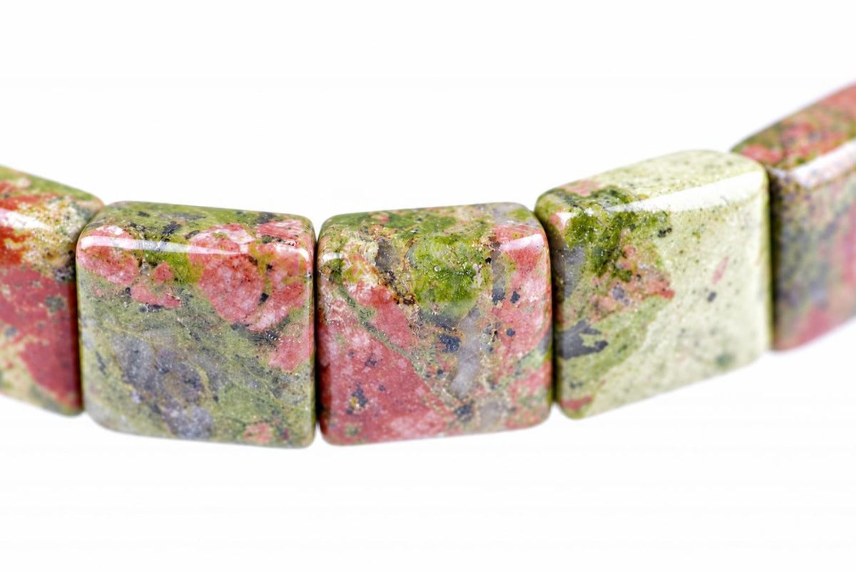 A bracelet of polished square beads with pink, green and grey speckled patterns on a white background.