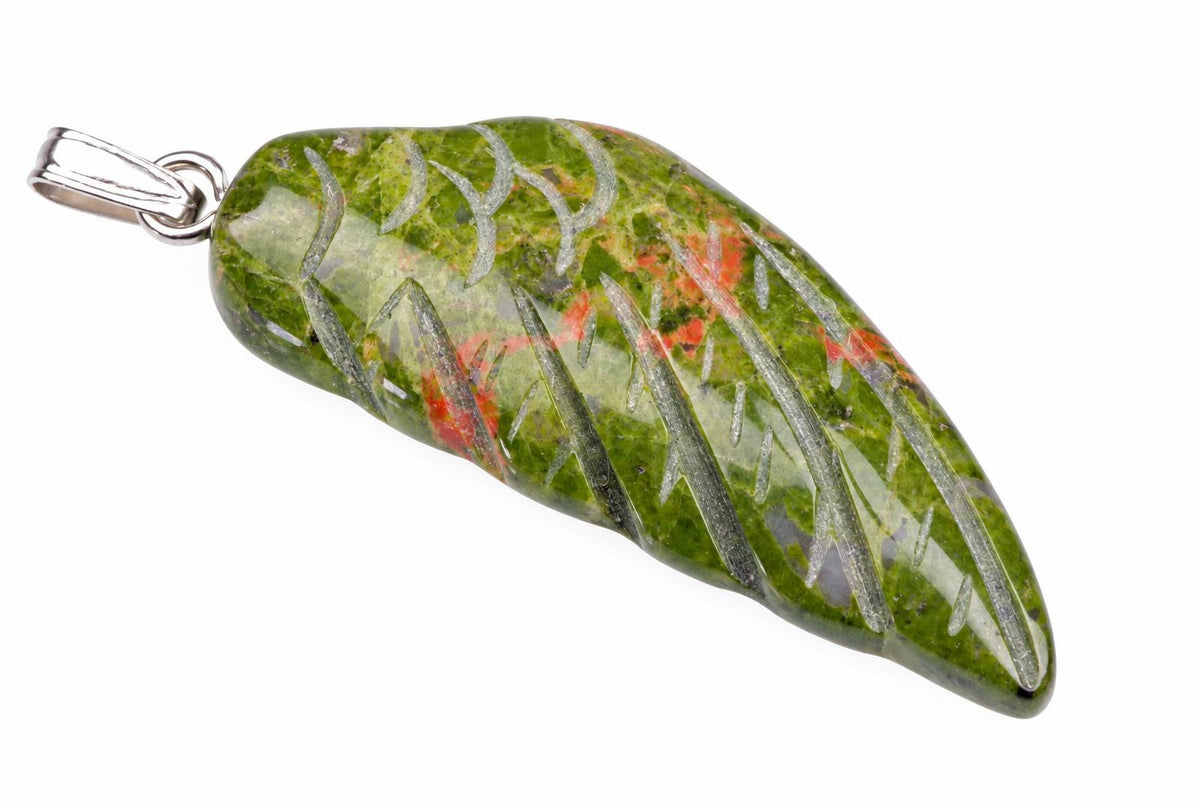 A polished green unakite pendant with red and grey inclusions, carved into a wing shape, set in silver-toned metal on a white background.