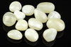 Twelve polished white and cream-coloured stones with subtle banding, arranged on a dark reflective surface.
