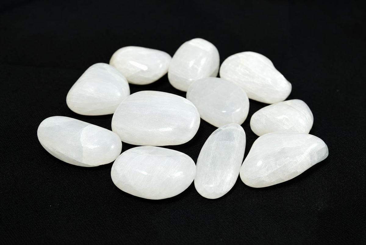 A group of smooth, white stones with a polished surface arranged on a dark background.
